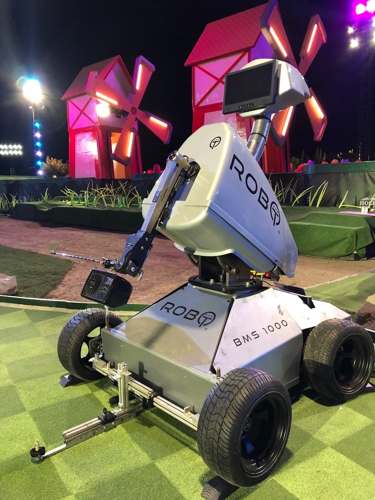 ROBO BMS 1000 on the Holey Moley set with the show's red windmill obstacles behind him